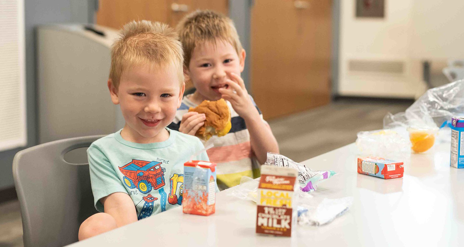 Two children eating a free summer meal at the library